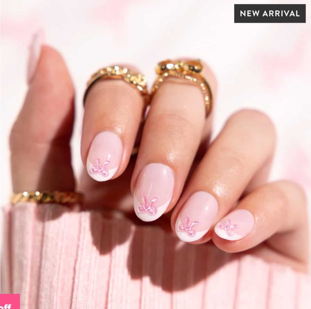 short almond press on nails come in a pink shiny finish with a french and 3D bow nail design.